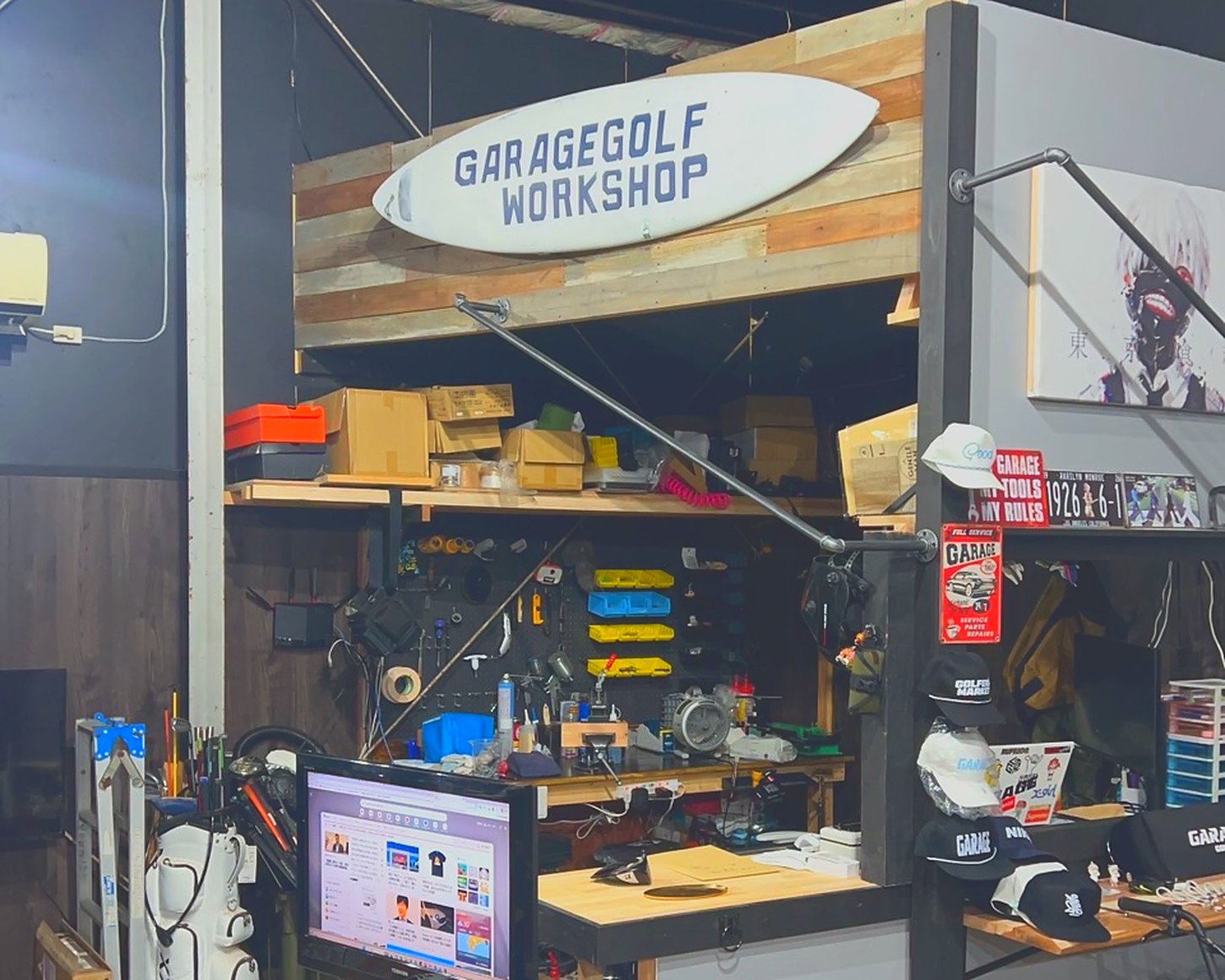 工房。手描きのサーフボード看板 GARAGEGOLF WORKSHOP と工具のペグボード、作業台